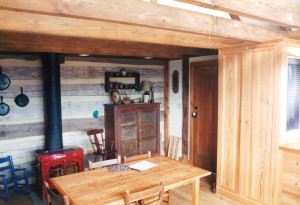 Finished interior where timber frame meets log cabin - Handmade Houses